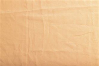 Fragment of smooth orange linen tissue. Top view, flat lay, natural textile background and texture