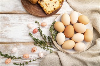 Homemade easter pie with raisins and eggs on plate on a white wooden background and linen textile.