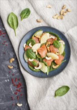 Fresh salmon with pineapple, spinach and cashew on a black concrete background. Top view, flat lay,