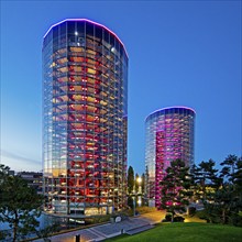 The illuminated car towers with new cars for delivery in the evening, Autostadt, Volkswagen AG,