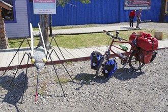 Bicycle with luggage next to an oversized mosquito, Carcross, Yukon Territory, Canada, North