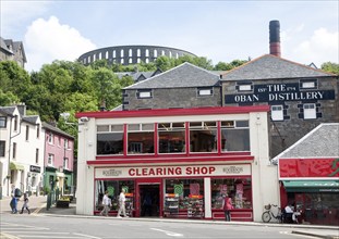 Distillery and shops Oban, Argyll and Bute, Scotland, UK with McCaig's Tower in the background