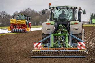 Tractor with a power harrow prepares the soil of a field for planting, Agriculture, Spring