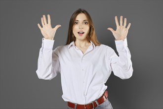 Surprised young woman shows ten fingers. Counting with fingers concept