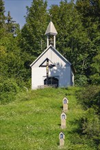 Chapel on a hill in the forest, surrounded by graves. Summer holiday atmosphere, Gundringen,