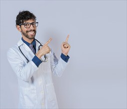 Bearded doctor pointing a promotion with finger isolated. Happy bearded doctor pointing at