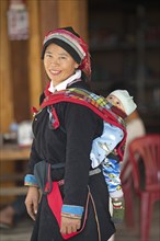 Vietnamese woman, 43 years old, in traditional traditional costume of the Dao minority, carrying