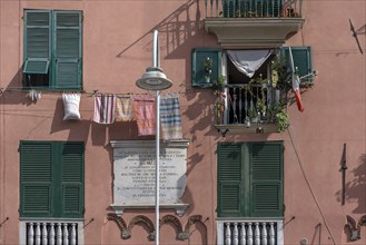 Residential building façade with green shutters and hanging laundry in the historic city centre,