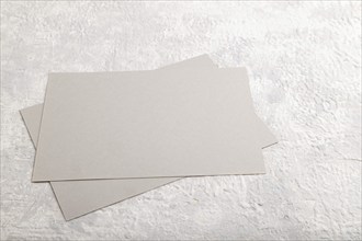 Gray paper business card, mockup on gray concrete background. Blank, flat lay, top view, still