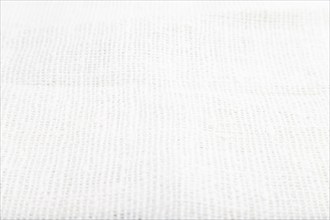 Fragment of smooth white linen tissue. Side view, natural textile background and texture