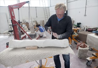 Sculptors working on local Portland stone in a community studio space on the Isle of Portland,