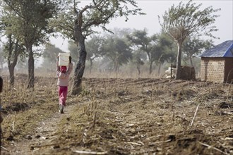 Girl carrying a heavy bucket of water on her head, Maraban Dare, 07/02/2024