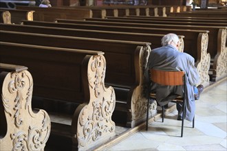 Old grey-haired man as the only churchgoer, interior of the Cistercian Abbey Church Fürstenfeld in