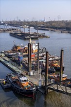 Hamburg harbour, Travehafen, working boats and barges, jetty, city skyline in the background,