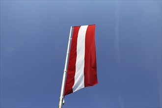 Österreichische Flagge vor blauem Himmel (Austrian flag in front of a blue sky)