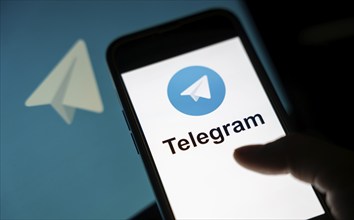 The social media Telegram messenger logo is being displayed on a smartphone screen and on a