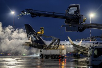 Winter at Frankfurt Main Airport, FRA, Lufthansa aircraft being de-iced by de-icing vehicles,