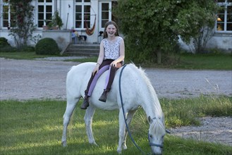 Girl, 10 years old sitting on her horse, Othenstorf, Mecklenburg-Vorpommern, Germany, Europe