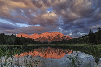 Mountains and clouds reflected in lake, evening light, cloudy mood, summer, Luttensee, Mittenwald,