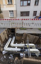 Construction site of a district heating house connection, pipes, insulated, are laid from a central