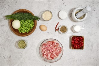 Top view of ingredients for meatballs with cranberry sauce and green peas