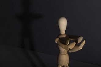 Wooden mannequin shows obscene gesture fuck off with hands on gray background. protest, riot,