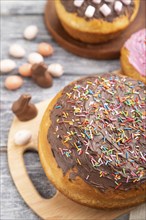 Homemade glazed and decorated easter pies with chocolate eggs and rabbits on a gray wooden