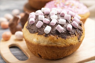 Homemade glazed and decorated easter pies with chocolate eggs and rabbits on a gray wooden