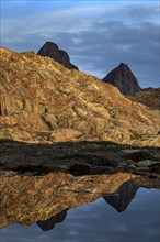 Mountains and rocks reflected in fjord, midnight sun, mood, Scoresby Sound, East Greenland,