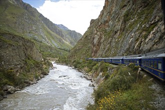 Perurail train travelling through the Andes from Ollantaytambo to Machu Picchu, in front the river