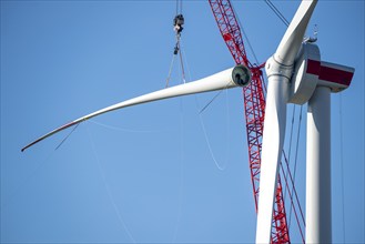 Assembly of a wind turbine, the last rotor blade is being mounted, mobile crane, wind turbine from