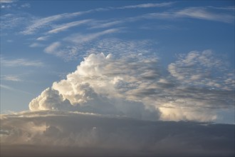 Towering cumulonimbus cloud, thundercloud, thunderstorm over the Swabian Alb illuminated by the