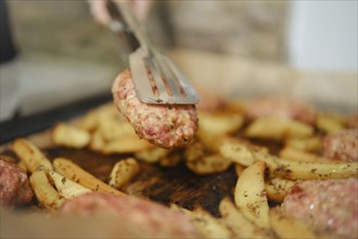 Baked in oven beef meat cutlet in kitchen tongs