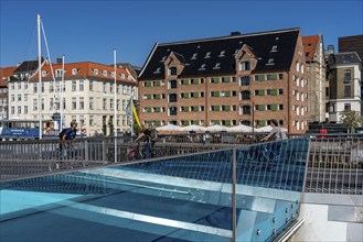 Cyclists on the Inderhavnsbroen cycle and footpath bridge, over the harbour, at Nyhavn, Copenhagen