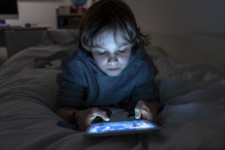 A boy plays computer games on a tablet PC