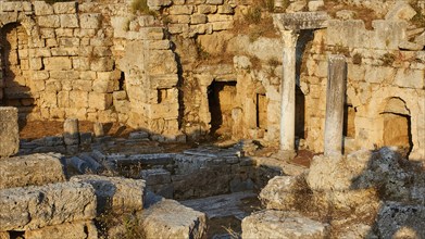 The remains of an ancient columned structure under a sunny sky, Peirene Fountain, Archaeological