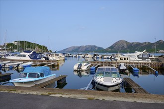 A quiet harbour with several sailing and motor boats, surrounded by Bergen, Sandnes, Fylke