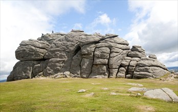 People scrambling on the granite tor of Haytor, Dartmoor national park, Devon, England, UK