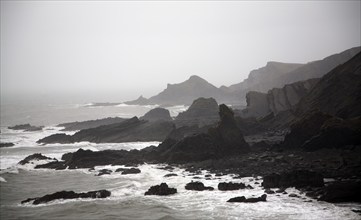 Large Atlantic storm waves crashing onto jagged rocky coast at Hartland Quay, north Devon, England,