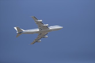 Boeing 747-200B or E4 aircraft of the United States Air Force USAF flying across a blue sky,