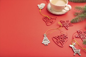 Christmas or New Year composition. Decorations, fir and spruce branches, cup of coffee, on a red