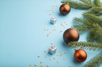 Christmas or New Year composition. Decorations, bronze balls, fir and spruce branches, on a blue