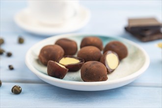 Japanese rice sweet buns chocolate mochi filled with cream and cup of green tea on blue wooden