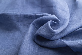 Fragment of blue linen tissue. Side view, natural textile background and texture. wave concept,