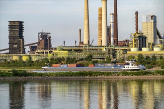 Industrial backdrop of the ThyssenKrupp Steel steelworks in Bruckhausen, on the Rhine, cargo ship,