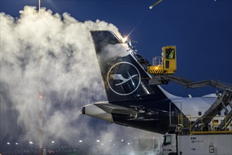 Winter at Frankfurt Main Airport, FRA, Lufthansa aircraft being de-iced by de-icing vehicles,