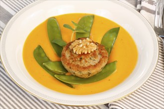 Vegetarian cuisine, walnut cakes on sugar snap peas with pumpkin sauce, sauce, vegetables, snow