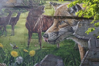 Vibrant mural depicting a fox, deer and a green meadow with flowers and trees, Mural Trail,