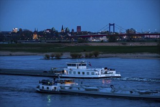 Cargo ship on the Rhine near Duisburg-Beeckerwerth, skyline of the city centre, with town hall,