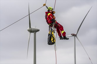 Height rescuers from the Oberhausen fire brigade practise abseiling from a wind turbine from a